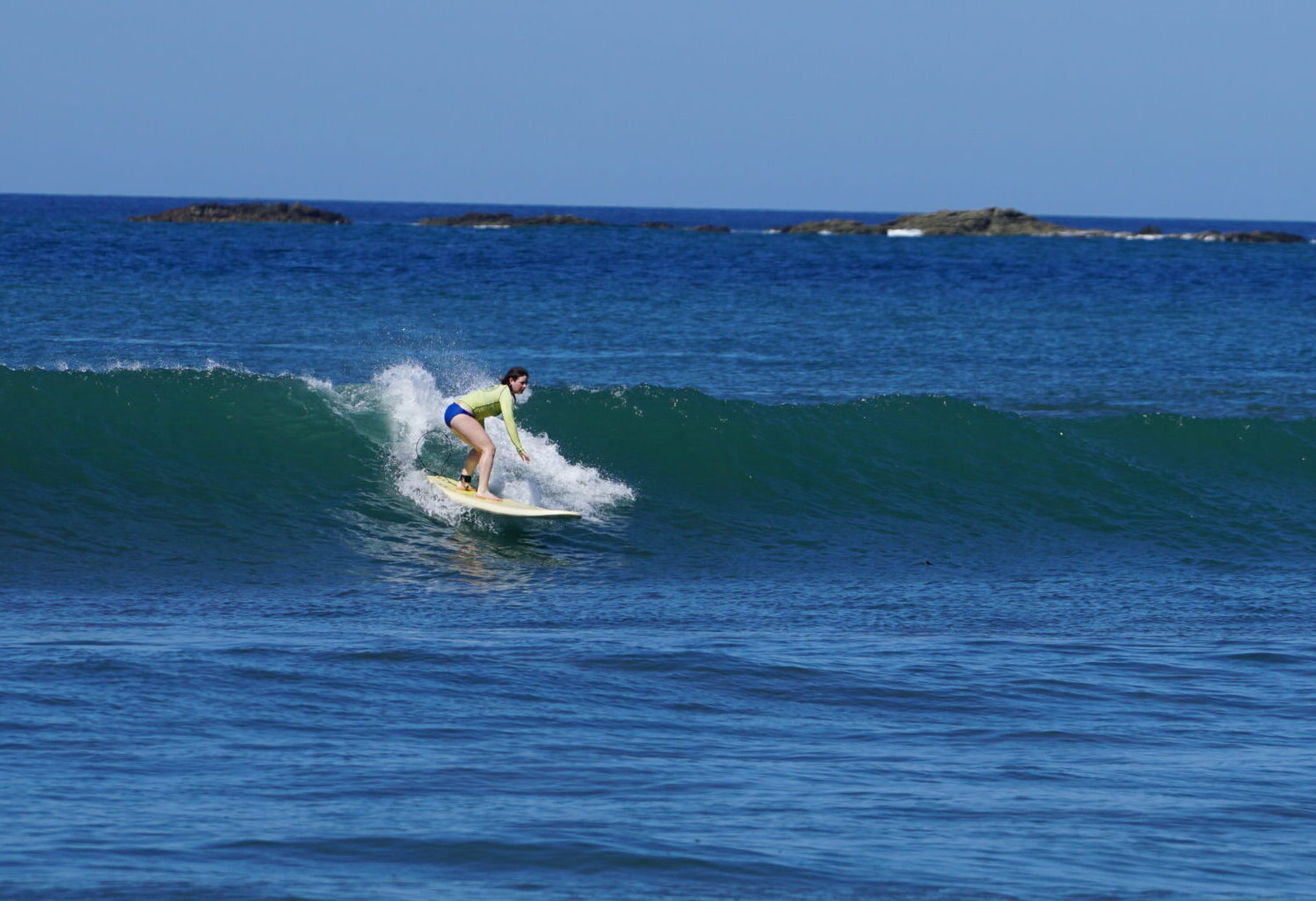 Surf Lesson with surfer girl in Costa Rica surfer girl catches a wave at Surf Lesson in Costa Rica