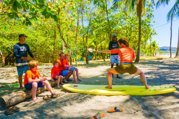 Mom stands up on the board during her Costa Rica Family Surf Lesson at Costa Rica Surf Trip!