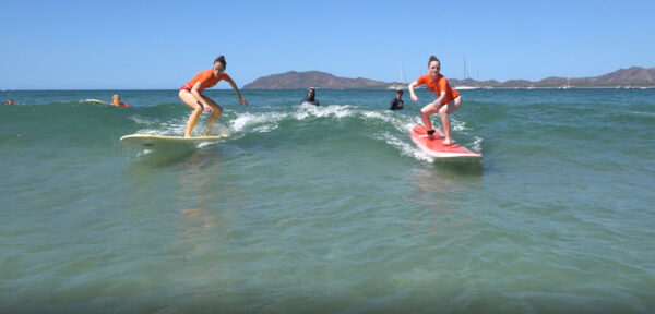 Girls surfing during their lesson in Costa Rica with Costa Rica Surf Trip!