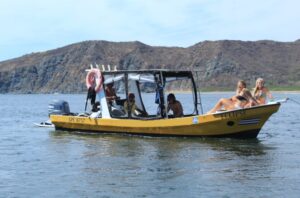 A yellow Witch's Rock Boat Trip Panga takes surfers out to the famous surf spot in Costa Rica