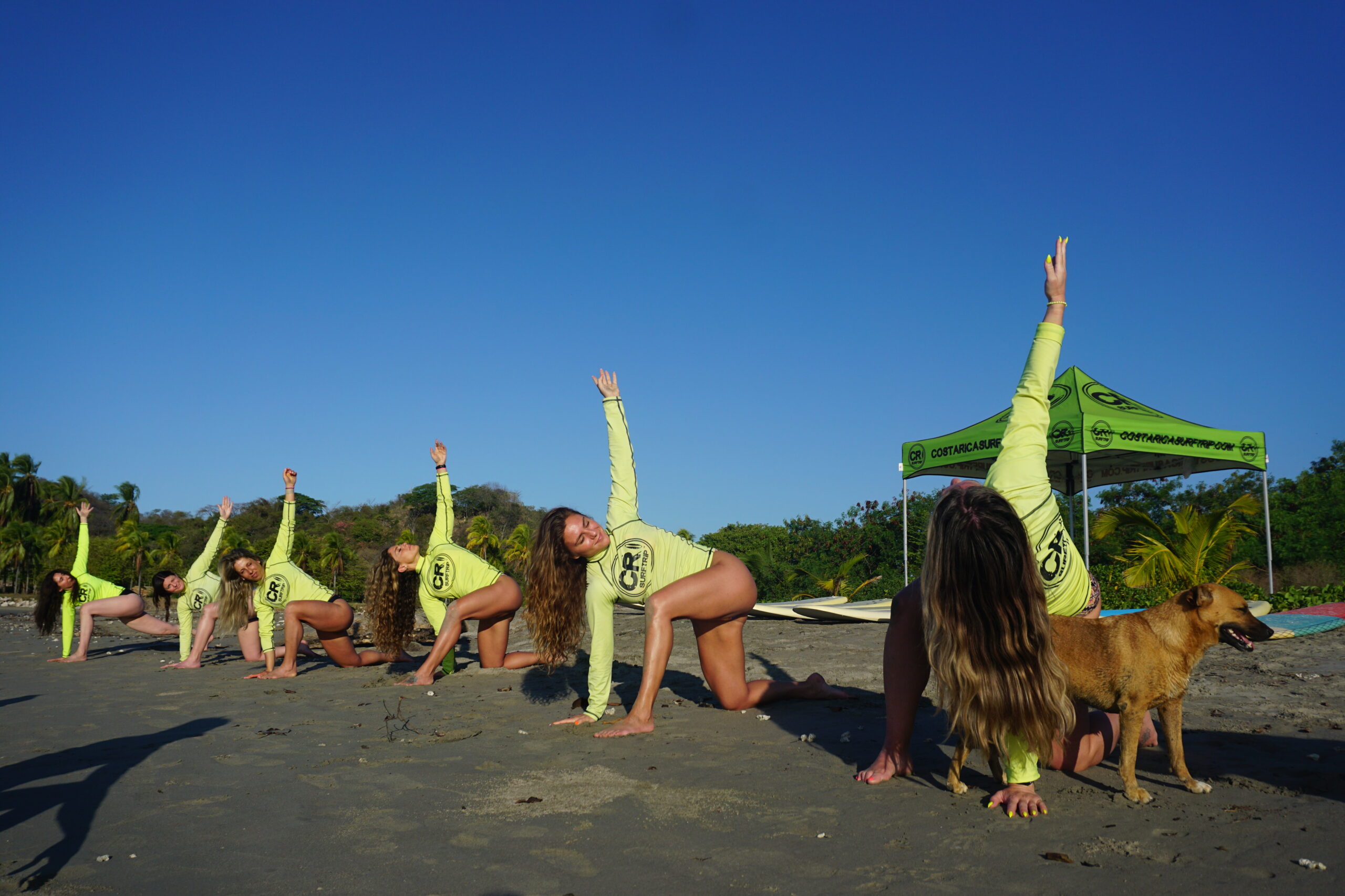 Surfers warm up on the beach with stretching and yoga for their surf lesson during their surf and fitness camp in Playa Samara, Costa Rica