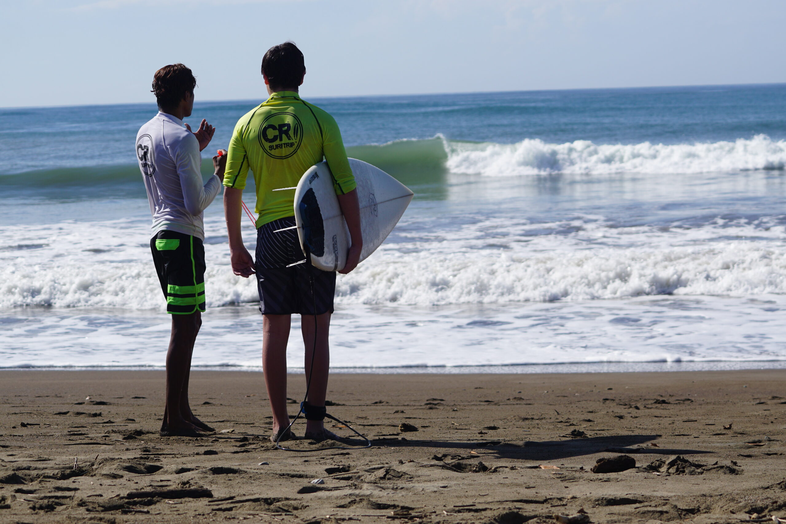 Coach Jairo teaches his student during surf coaching session in Costa Rica