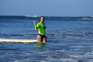 Surfer girl gives a peace sign at her surf lesson during Samara Surf Camp in Costa Rica!