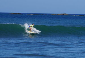 surfer girl catches a wave at Surf Lesson in Costa Rica
